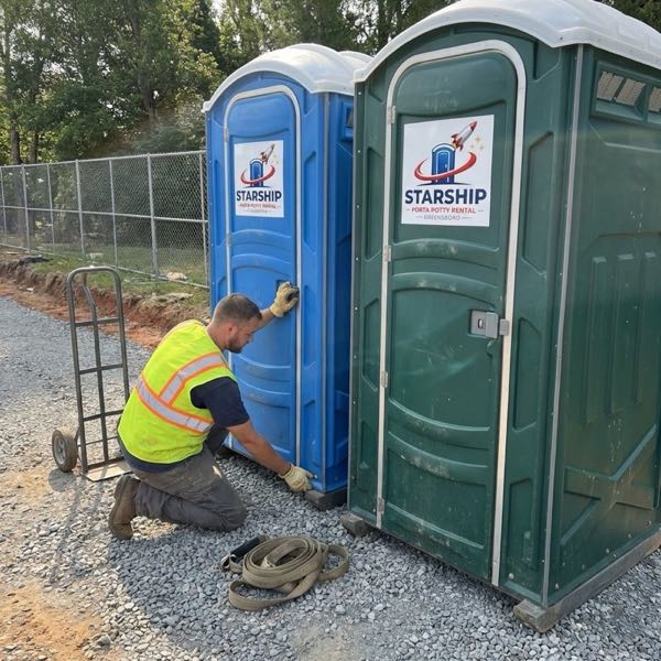 Technician servicing portable toilets on site
